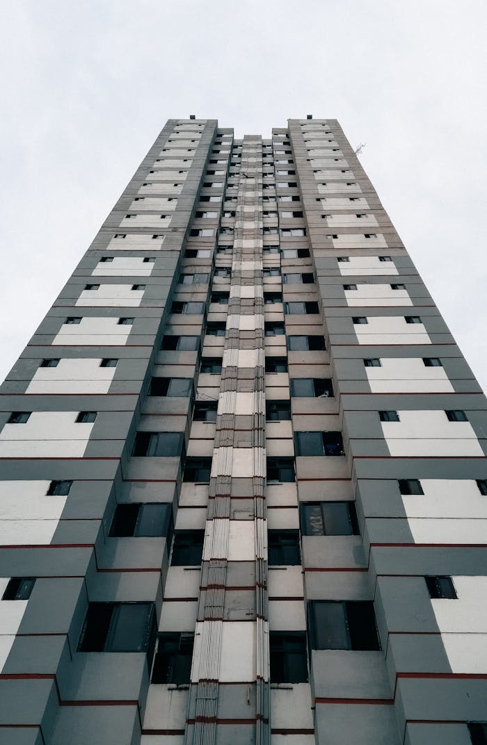 why-choose-us Low-angle shot of a tall building in Dhaka, showcasing modern architectural design.